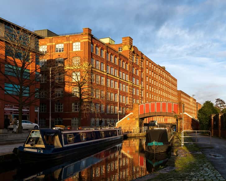 An image of buildings and a boat in the light of the sunset.
